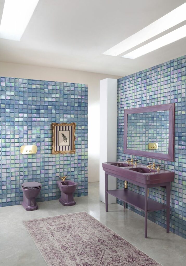 WC, bidet e lavabo consolle doppio in ceramica Viola Lavanda, rubinetteria oro, parete in mosaico di vetro iridescente